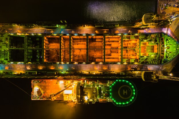 A detailed view of a custom-built mining rig with multiple high-end GPUs, illuminated by LED lights. The image focuses on the intricate connections and cooling systems, visually representing the hardware investment and electrical infrastructure required for effective mining.